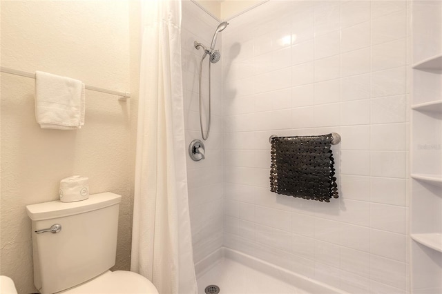 full bathroom with toilet, a shower stall, and a textured wall