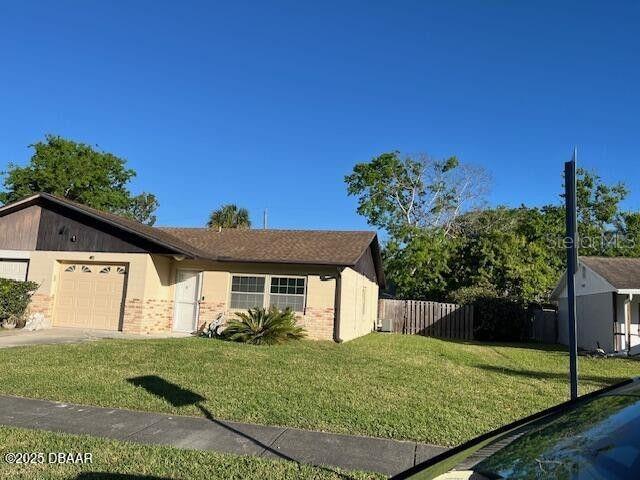 908 Boulder Dr, South Daytona, FL 32119 - view of front facade with brick siding, a garage, and driveway