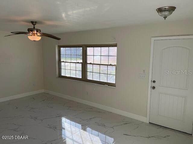 908 Boulder Dr, South Daytona, FL 32119 - foyer entrance with marble look tile flooring, baseboards, and a ceiling fan