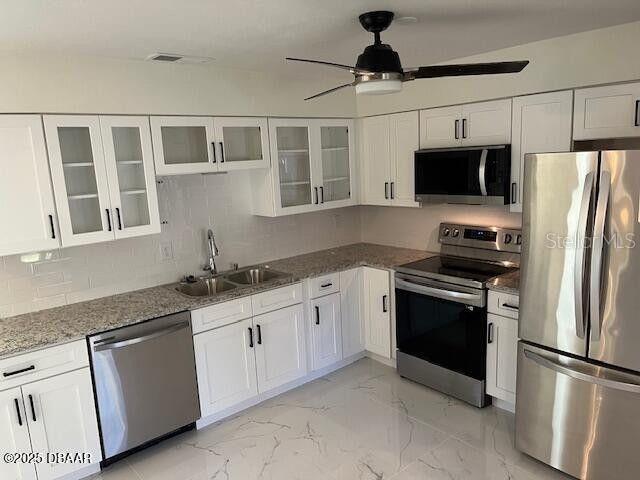 908 Boulder Dr, South Daytona, FL 32119 - kitchen with appliances with stainless steel finishes, a sink, white cabinetry, and ceiling fan