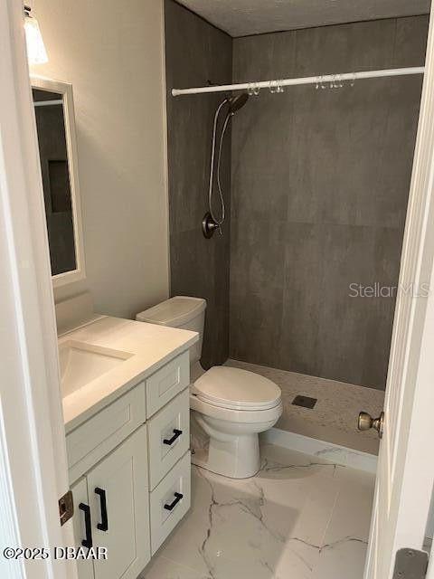 908 Boulder Dr, South Daytona, FL 32119 - full bath with marble look tile flooring, a shower stall, vanity, and toilet