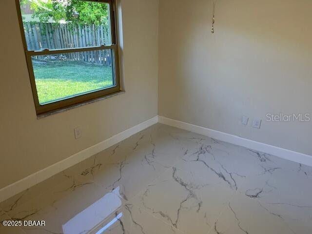 908 Boulder Dr, South Daytona, FL 32119 - spare room featuring baseboards and marble finish flooring