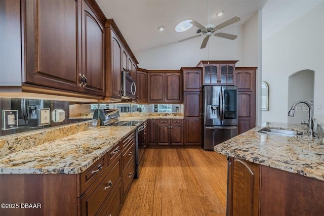 3601 Galway Ln, Ormond Beach, FL 32174 - kitchen featuring appliances with stainless steel finishes, a sink, ceiling fan, light stone countertops, and arched walkways