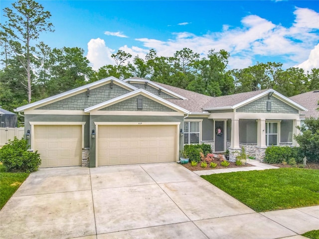 409 Nowell Loop, Deland, FL 32724 - view of front of home featuring stucco siding, stone siding, and an attached garage