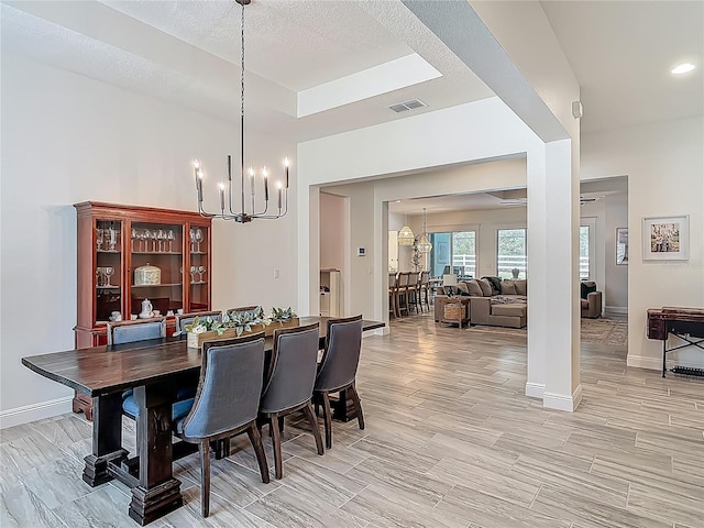 409 Nowell Loop, Deland, FL 32724 - dining space with a chandelier, baseboards, and light wood-style floors