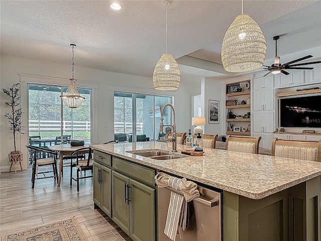 409 Nowell Loop, Deland, FL 32724 - kitchen with a sink, a textured ceiling, healthy amount of natural light, a ceiling fan, and a center island with sink
