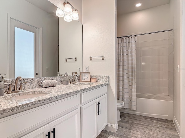 409 Nowell Loop, Deland, FL 32724 - bathroom featuring toilet, double vanity, shower / bath combination with curtain, wood finished floors, and baseboards