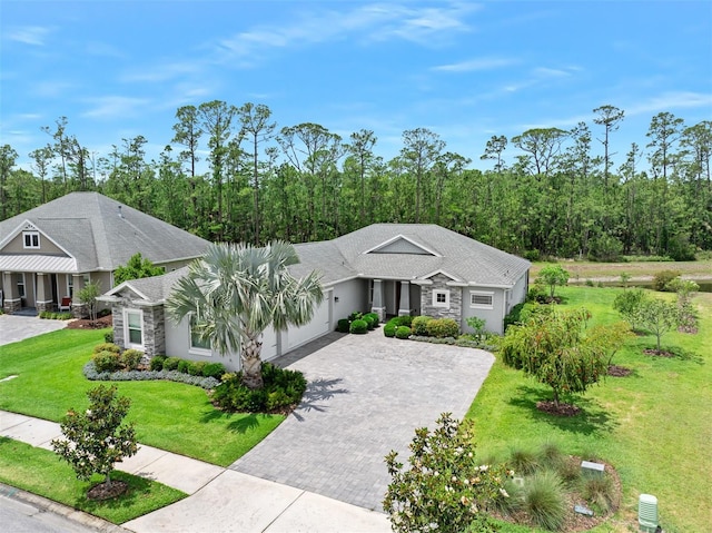3322 Modena Way, New Smyrna Beach, FL 32168 - ranch-style home featuring stone siding, a garage, decorative driveway, and a front yard