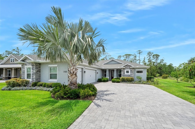 3322 Modena Way, New Smyrna Beach, FL 32168 - view of front of home featuring stone siding, an attached garage, decorative driveway, a front lawn, and stucco siding