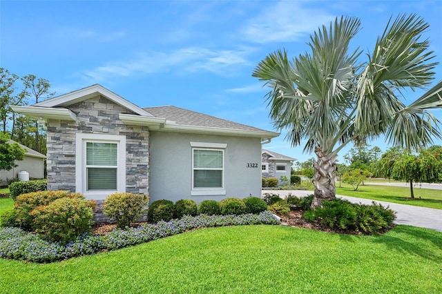 3322 Modena Way, New Smyrna Beach, FL 32168 - view of property exterior featuring stone siding, a lawn, and stucco siding