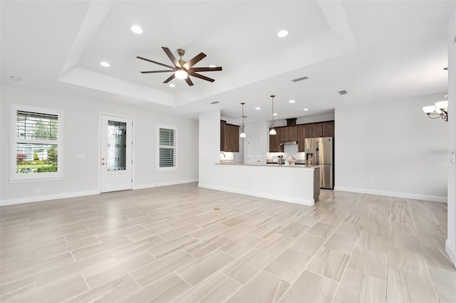 3322 Modena Way, New Smyrna Beach, FL 32168 - unfurnished living room with a raised ceiling, a ceiling fan, a chandelier, recessed lighting, and baseboards