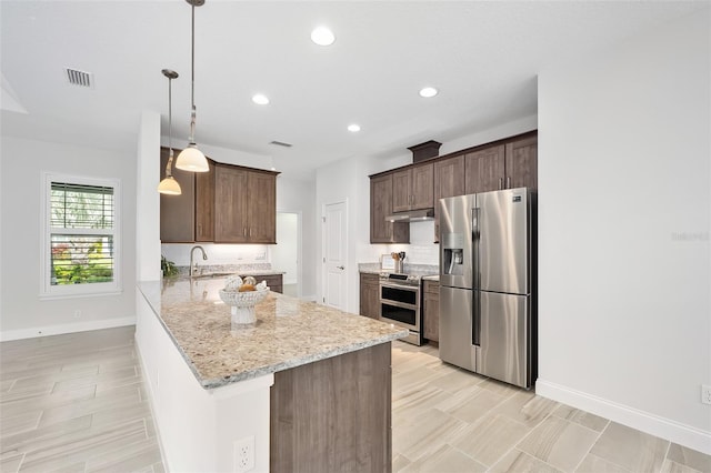 3322 Modena Way, New Smyrna Beach, FL 32168 - kitchen with appliances with stainless steel finishes, baseboards, recessed lighting, a peninsula, and dark brown cabinetry