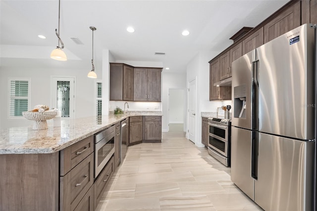 3322 Modena Way, New Smyrna Beach, FL 32168 - kitchen with appliances with stainless steel finishes, a peninsula, light stone countertops, under cabinet range hood, and a sink
