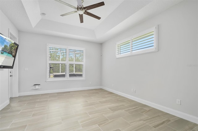 3322 Modena Way, New Smyrna Beach, FL 32168 - unfurnished room with a tray ceiling, healthy amount of natural light, ceiling fan, and baseboards