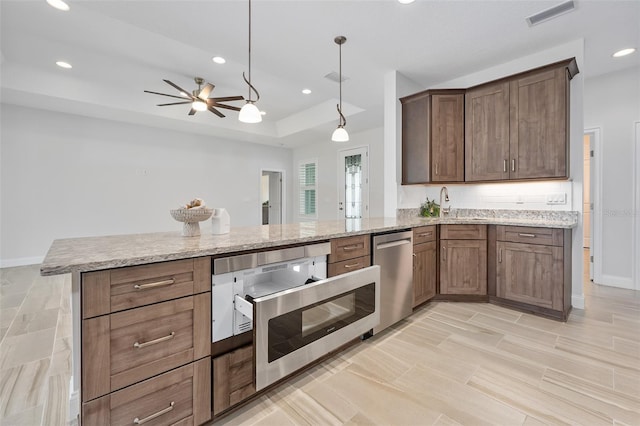 3322 Modena Way, New Smyrna Beach, FL 32168 - kitchen with stainless steel appliances, recessed lighting, light stone counters, a ceiling fan, and a peninsula