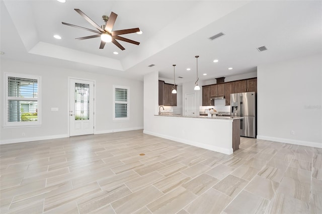 3322 Modena Way, New Smyrna Beach, FL 32168 - unfurnished living room featuring a raised ceiling, ceiling fan, recessed lighting, a sink, and baseboards