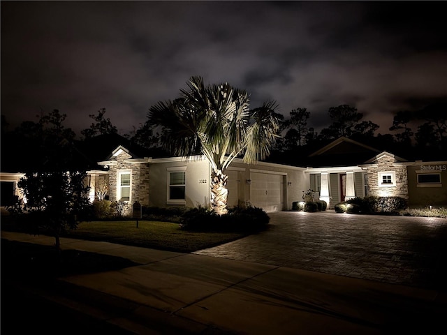 3322 Modena Way, New Smyrna Beach, FL 32168 - view of front of home featuring stone siding, a garage, decorative driveway, and stucco siding