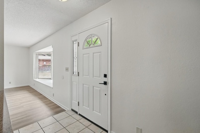 1209 James Ter, Daytona Beach, FL 32117 - entryway with a textured ceiling, plenty of natural light, light tile patterned flooring, and baseboards