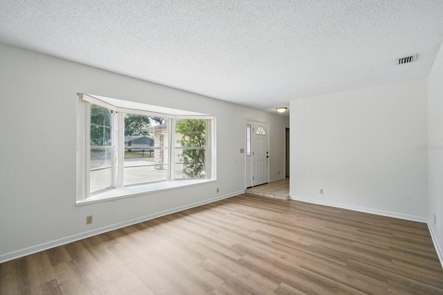 1209 James Ter, Daytona Beach, FL 32117 - unfurnished living room featuring wood finished floors, a textured ceiling, and baseboards