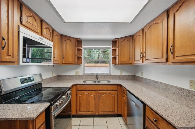 1209 James Ter, Daytona Beach, FL 32117 - kitchen featuring appliances with stainless steel finishes, a sink, open shelves, and brown cabinets