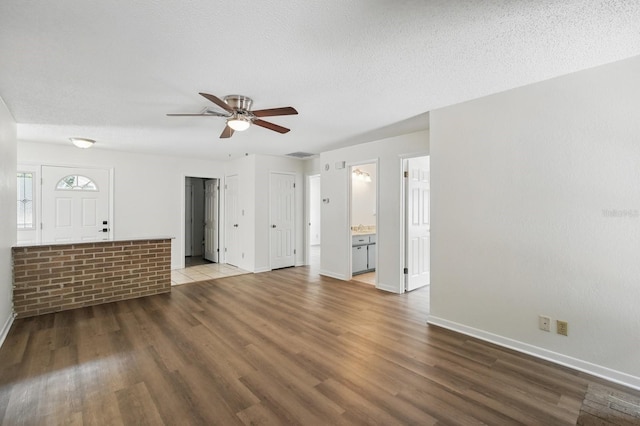 1209 James Ter, Daytona Beach, FL 32117 - unfurnished living room featuring wood finished floors, baseboards, a ceiling fan, and a textured ceiling