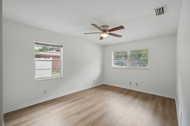 1209 James Ter, Daytona Beach, FL 32117 - spare room featuring healthy amount of natural light, wood finished floors, a textured ceiling, a ceiling fan, and baseboards
