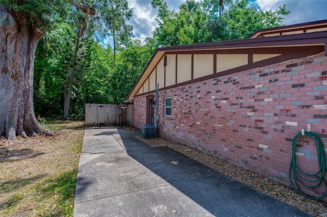 818 Sugar House Blvd, Port Orange, FL 32129 - view of home's exterior featuring a gate, brick siding, board and batten siding, and central air condition unit