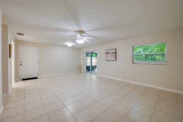 818 Sugar House Blvd, Port Orange, FL 32129 - empty room with ceiling fan, a textured ceiling, baseboards, and light tile patterned floors