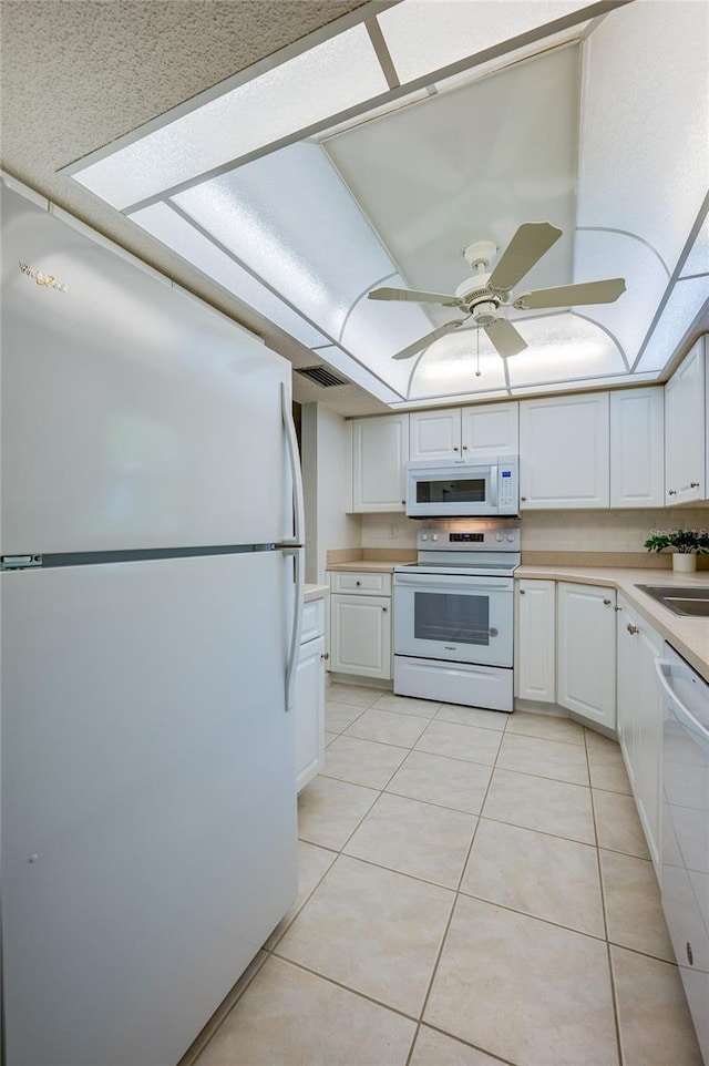 818 Sugar House Blvd, Port Orange, FL 32129 - kitchen with white appliances, light tile patterned flooring, light countertops, white cabinets, and a ceiling fan