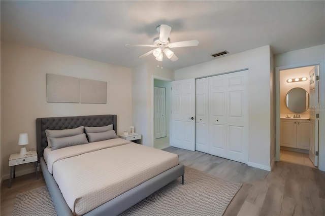 818 Sugar House Blvd, Port Orange, FL 32129 - bedroom with light wood-style floors, a closet, a sink, baseboards, and ensuite bathroom