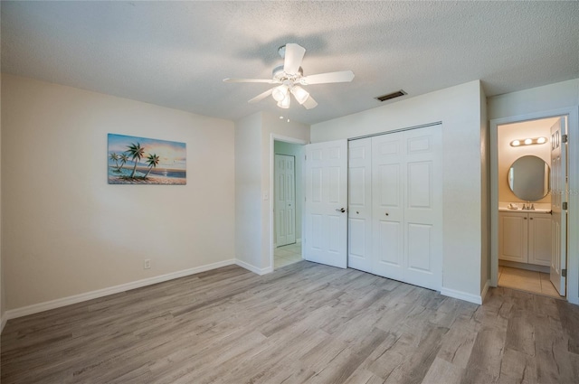 818 Sugar House Blvd, Port Orange, FL 32129 - unfurnished bedroom with wood finished floors, a sink, a textured ceiling, baseboards, and a closet