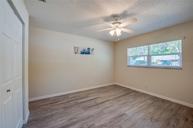 818 Sugar House Blvd, Port Orange, FL 32129 - empty room with wood finished floors, a textured ceiling, a ceiling fan, and baseboards