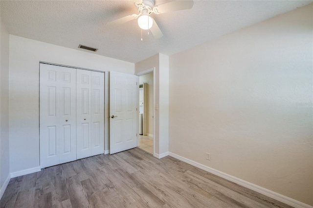 818 Sugar House Blvd, Port Orange, FL 32129 - unfurnished bedroom featuring wood finished floors, baseboards, a closet, a textured ceiling, and a ceiling fan