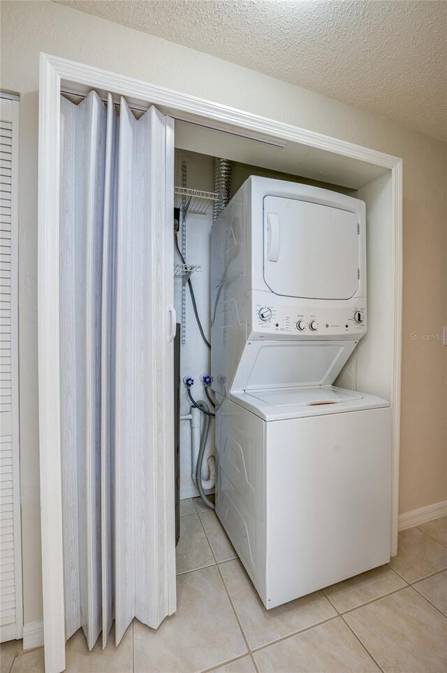 818 Sugar House Blvd, Port Orange, FL 32129 - washroom with stacked washer and clothes dryer, light tile patterned floors, and baseboards