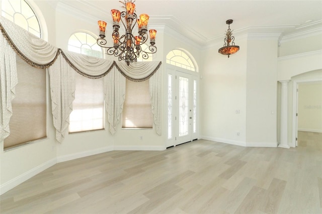 340 Hampton Hills Ct, Debary, FL 32713 - unfurnished dining area featuring a chandelier, wood finished floors, crown molding, ornate columns, and baseboards