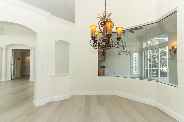 340 Hampton Hills Ct, Debary, FL 32713 - unfurnished dining area with wood finished floors, arched walkways, a chandelier, decorative columns, and ornamental molding