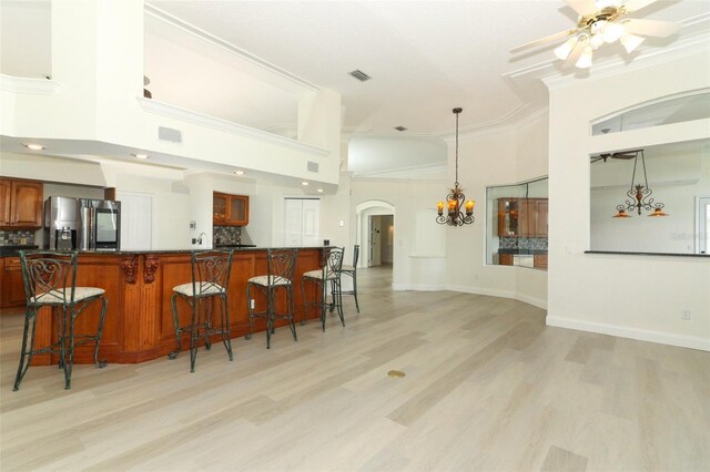 340 Hampton Hills Ct, Debary, FL 32713 - kitchen with stainless steel fridge, dark countertops, arched walkways, a kitchen bar, and crown molding