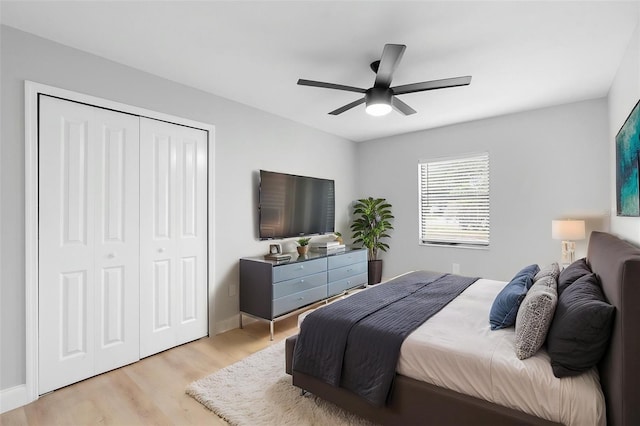bedroom featuring light wood finished floors, a closet, ceiling fan, and baseboards