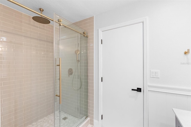 full bath with a shower stall and a wainscoted wall