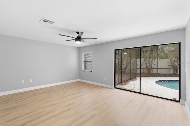 spare room with wood finished floors, baseboards, and a ceiling fan