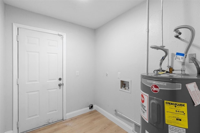 clothes washing area featuring water heater, light wood-style floors, hookup for a gas dryer, baseboards, and hookup for a washing machine
