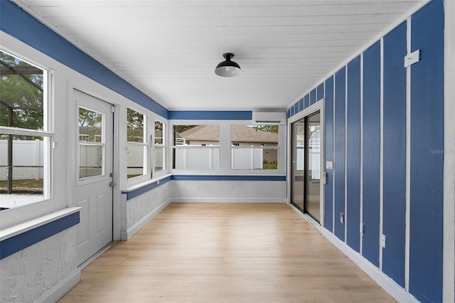 unfurnished sunroom featuring wood finished floors and baseboards