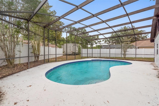 view of pool featuring a fenced backyard, a patio area, and glass enclosure