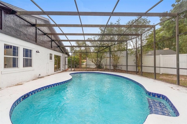 view of swimming pool with a fenced backyard and glass enclosure