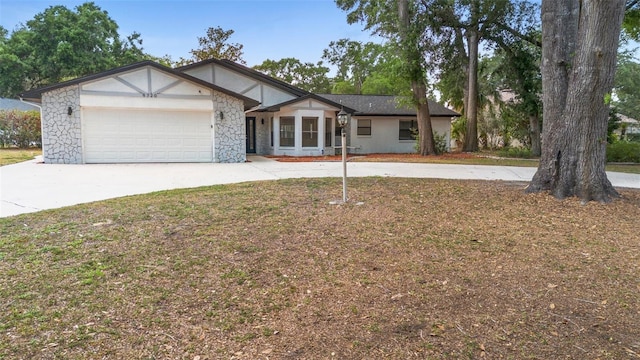 view of front of property with concrete driveway, stone siding, and an attached garage