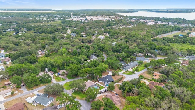 aerial view of property and surrounding area with a large body of water and nearby suburban area