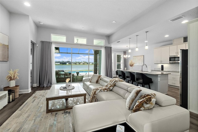 165 Azure Mist Way, Daytona Beach, FL 32124 - living room featuring dark wood finished floors, a water view, recessed lighting, and baseboards
