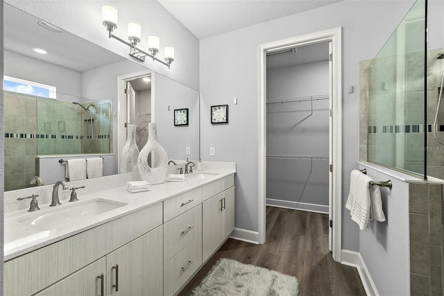 165 Azure Mist Way, Daytona Beach, FL 32124 - full bathroom with a walk in shower, wood finished floors, double vanity, a walk in closet, and baseboards