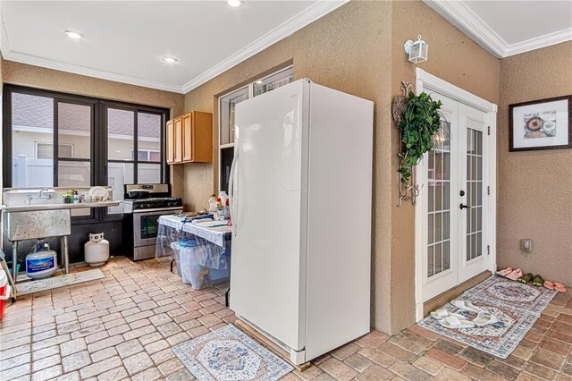 4604 Barbados Loop, Clermont, FL 34711 - kitchen with freestanding refrigerator, a textured wall, ornamental molding, stainless steel gas stove, and french doors