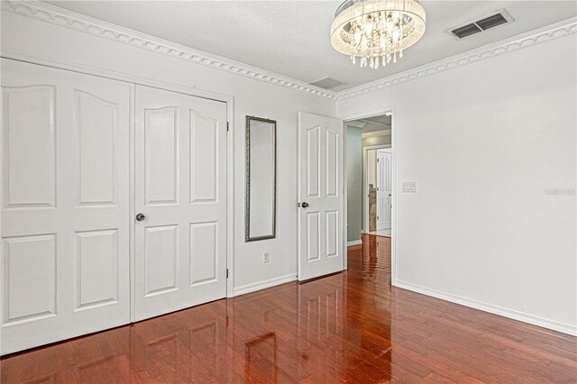 4604 Barbados Loop, Clermont, FL 34711 - unfurnished bedroom featuring baseboards, a chandelier, wood finished floors, and a closet